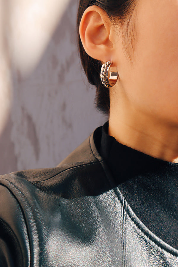 Side profile of model wearing chunky hoops in silver, showcasing the unique chain detail on the bold hoop design.