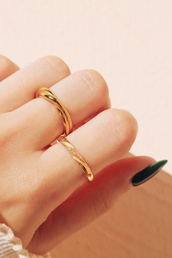 A close-up of gold dainty rings stacking on a hand, capturing its intricate details and fine craftsmanship.