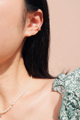 Girl in green dress weraing gold plated shiny ear clip to elevate her summer outfit