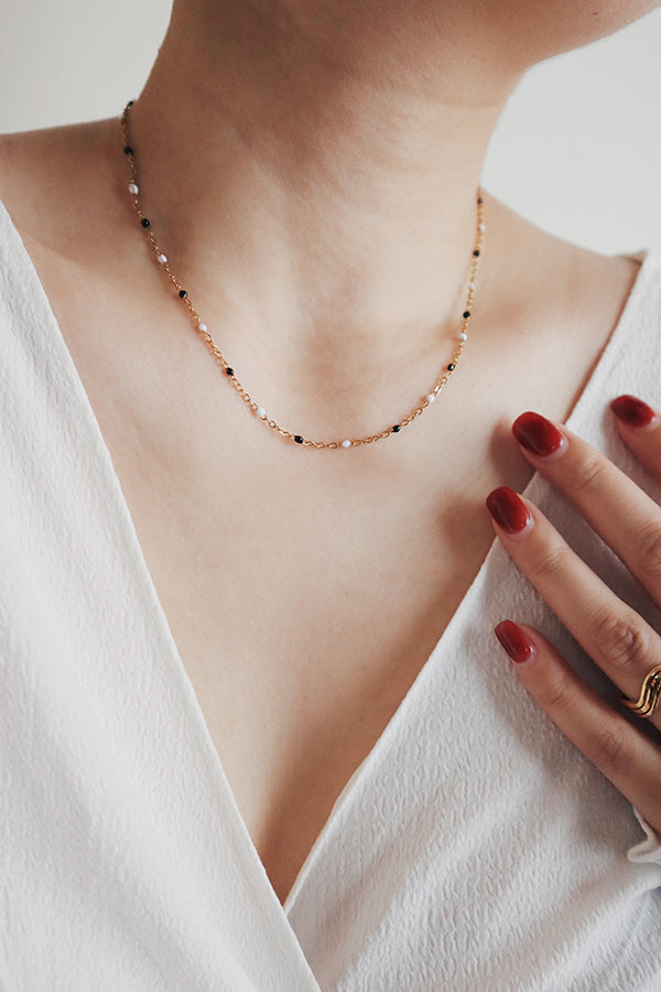 Woman level up her outfits with a black white beads necklace