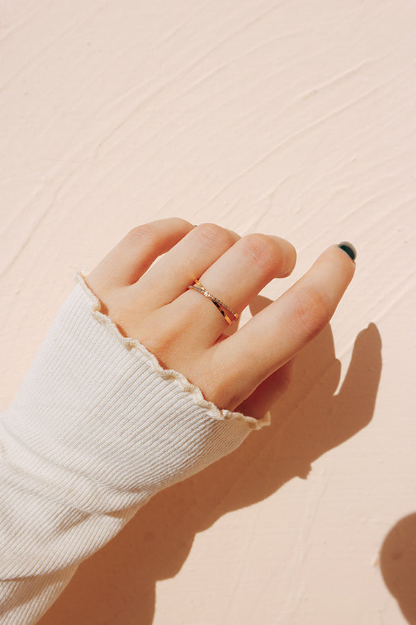 Hand wearing a delicate gold ring, showcasing minimalist style in a soft natural light setting, perfect for elegant and simple jewelry lovers.