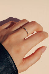 Woman wearing zircon dainty gold ring on her middle finger