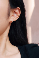 Girl wearing zoe shimmering gold huggie with a stunning ear clip