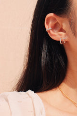 白洋裝女性以純銀抗敏感的耳環打造獨特活潑的疊戴風格