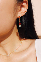 Side view of a woman wearing a versatile two-way earring with pearl and gemstone details, styled with a simple gold chain necklace featuring small pearls.