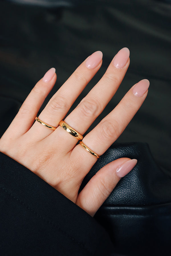 Girl stacks minimalist gold rings to elevate her outfit