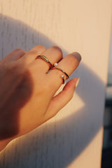 A woman mixing and matching a gold pearl ring by SH & Co with other jewelry pieces, emphasizing the ring's versatility and contemporary style.