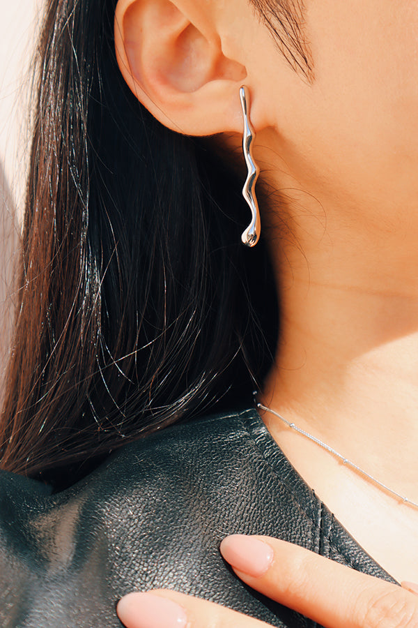 女性右耳配戴獨特流線造型銀色耳環打造酷帥穿衣風格