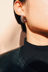 Side profile of model featuring the stainless steel hoop earrings in silver, highlighting the modern chain design and bold statement look.