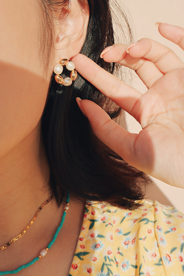 Woman wearing elegant pearl earring for her vacation outfit