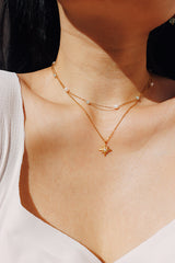 Close-up shot of a girl wearing a delicate jade and pearl choker necklace that is tarnish-free and water-resistant, showcasing its elegant simplicity against a warm skin tone.