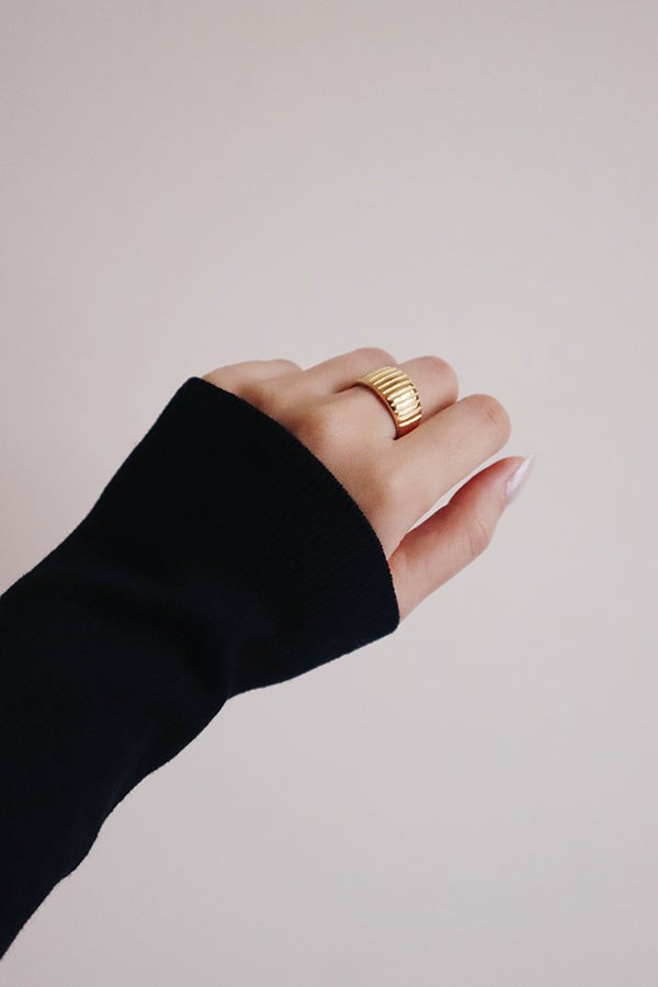 Gril showing her left hand with gold ring on middle finger to camera