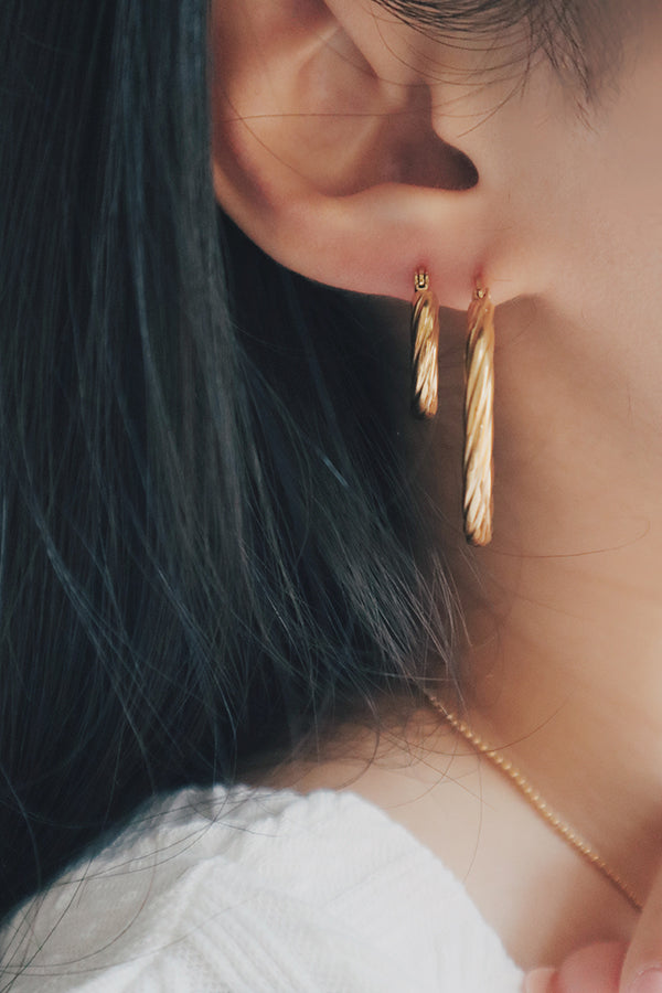 A product image displaying both the small and large versions of the twisted texture gold hoop earrings. The earrings are shown side by side, highlighting the difference in size and the intricate twisted texture that gives them a unique, stylish appearance.