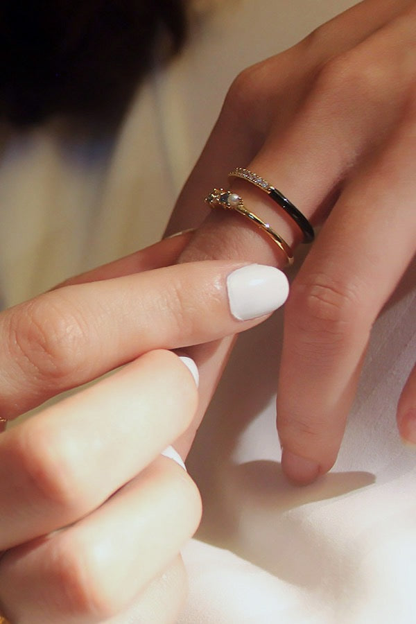 Enamel slim ring with zircon stacked with another gold ring on white nail polish on index finger from SH & Co.