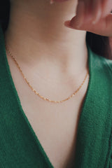 SH & Co. essential necklace, featuring an 18K gold plating, draped gracefully for a classic and timeless appearance.