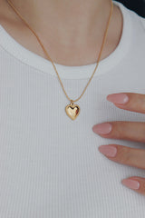 Gold heart beads necklace from SH & Co., with small heart-shaped pendants distributed along a slender gold chain, radiating subtle elegance.