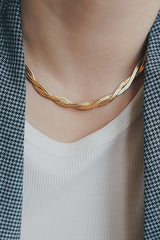 Gold snake necklace from SH & Co. Jewelry, displayed on a woman, characterized by its intricate links and glossy finish.