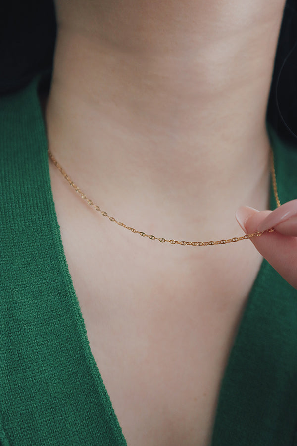 Sophisticated gold-plated necklace from SH & Co. draped elegantly, reflecting the high-quality craftsmanship.