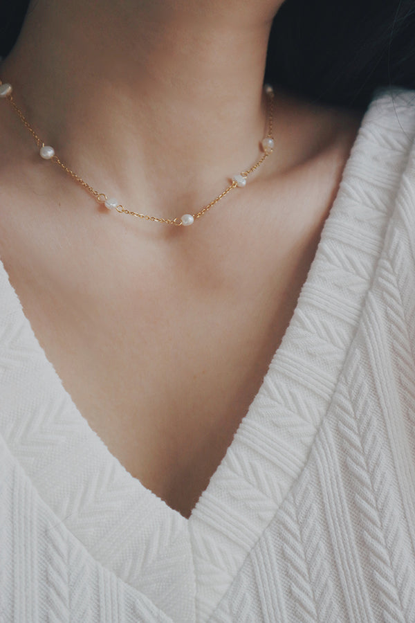 18K gold-plated Ivanna necklace featuring a central textured pendant surrounded by a layered chain with small pearls, blending classic charm with modern aesthetics.