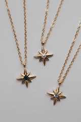 Collection of SH & Co. three star necklaces featuring cubic zirconia in white and green, and a pearl center.