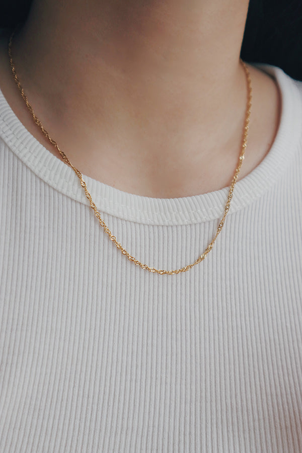 SH & Co.'s Singapore gold chain necklace, elegantly crafted with a twisted link design that offers a sophisticated shimmer.