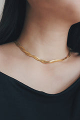 Elegant stainless steel herringbone necklace showcased on a woman, reflecting a modern and polished aesthetic.