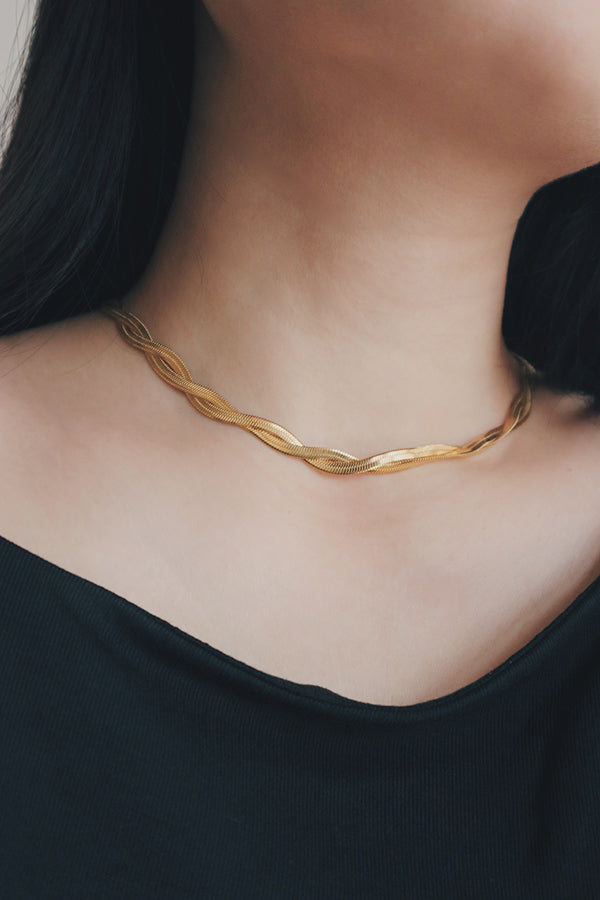 Elegant stainless steel herringbone necklace showcased on a woman, reflecting a modern and polished aesthetic.