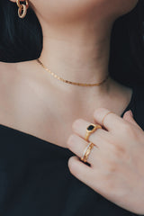 Tarnish-free gold choker displayed on a woman, highlighting its polished finish and durable quality, styled with a casual black top.