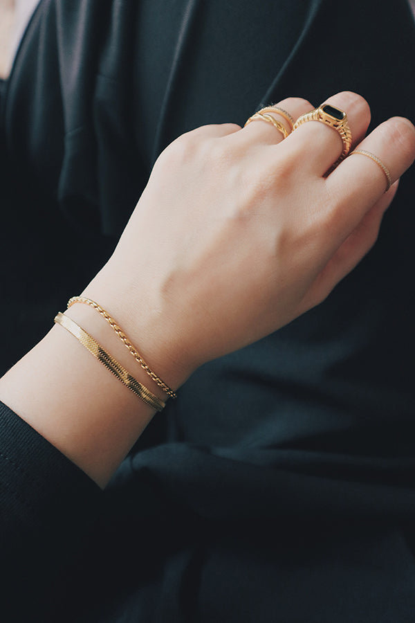 Close-up of a womans wrist wearing a tarnish-free rope chain bracelet, paired with a white textured sleeve, emphasizing the bracelets durability and refined look.