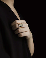 Formal attire girl wearing chunky gold ring with black backgroung